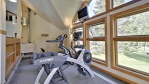 A gym with two exercise bikes, a treadmill, and a television on the wall. - Trail Creek: Ski home to renovated 1st floor, 1br condo. Sleeps 4. (Killington)