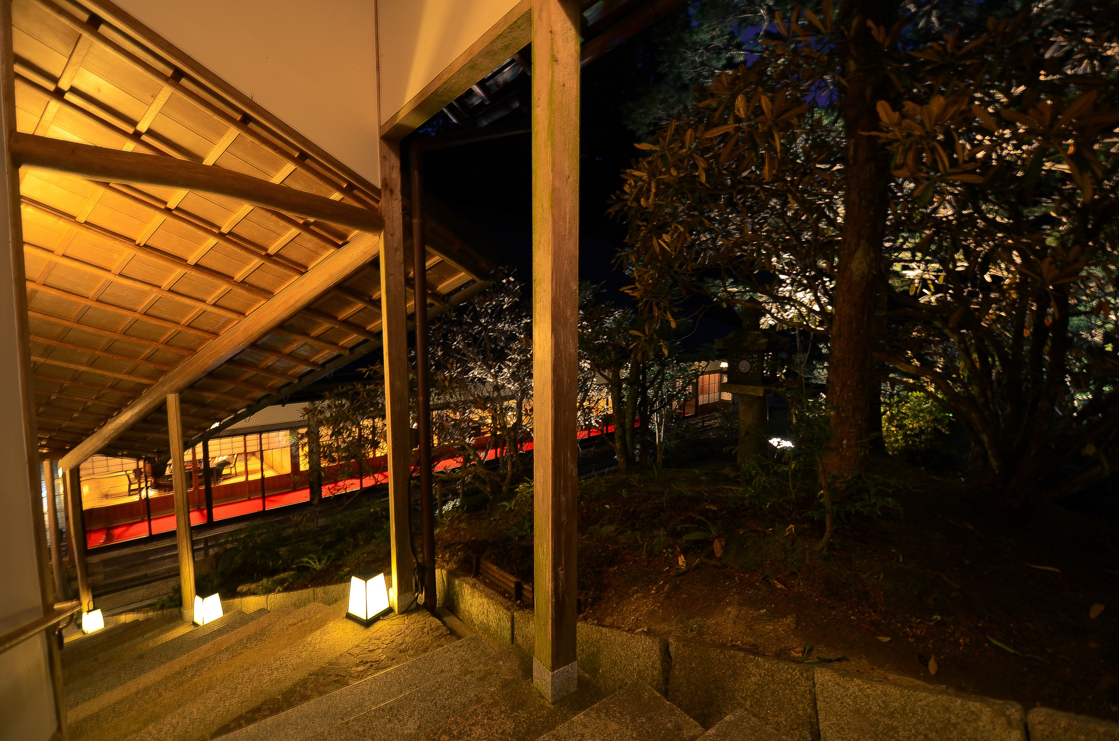 A covered outdoor area with wooden beams and steps leading to a platform.