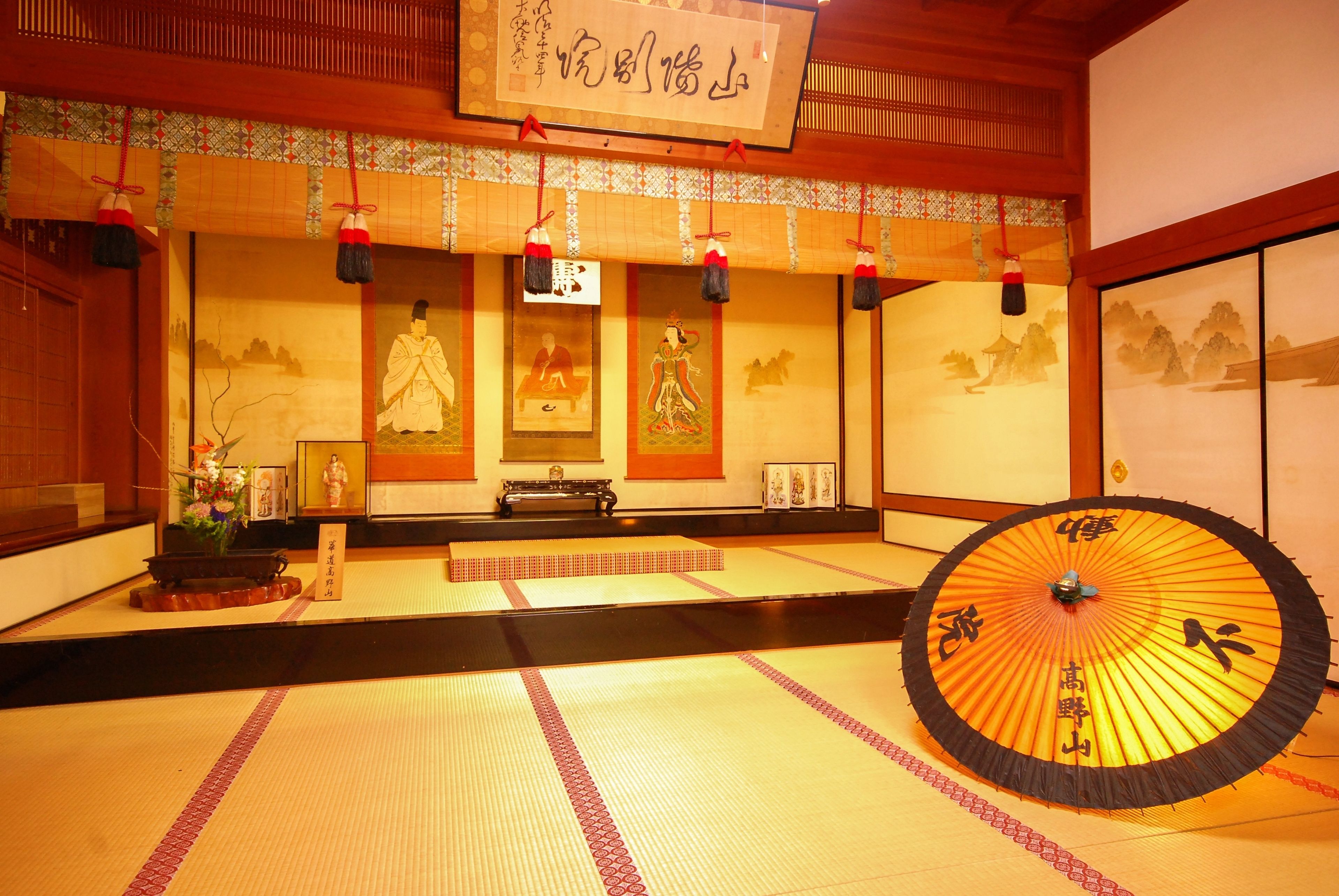 Una habitación japonesa tradicional con suelo de tatami, un biombio shoji y un shoji colgante con caligrafía.