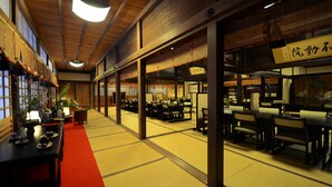 A traditional Japanese restaurant with tatami mat flooring, wooden tables, and a red carpet. - Koyasan Syukubou Fudouin (Koya)