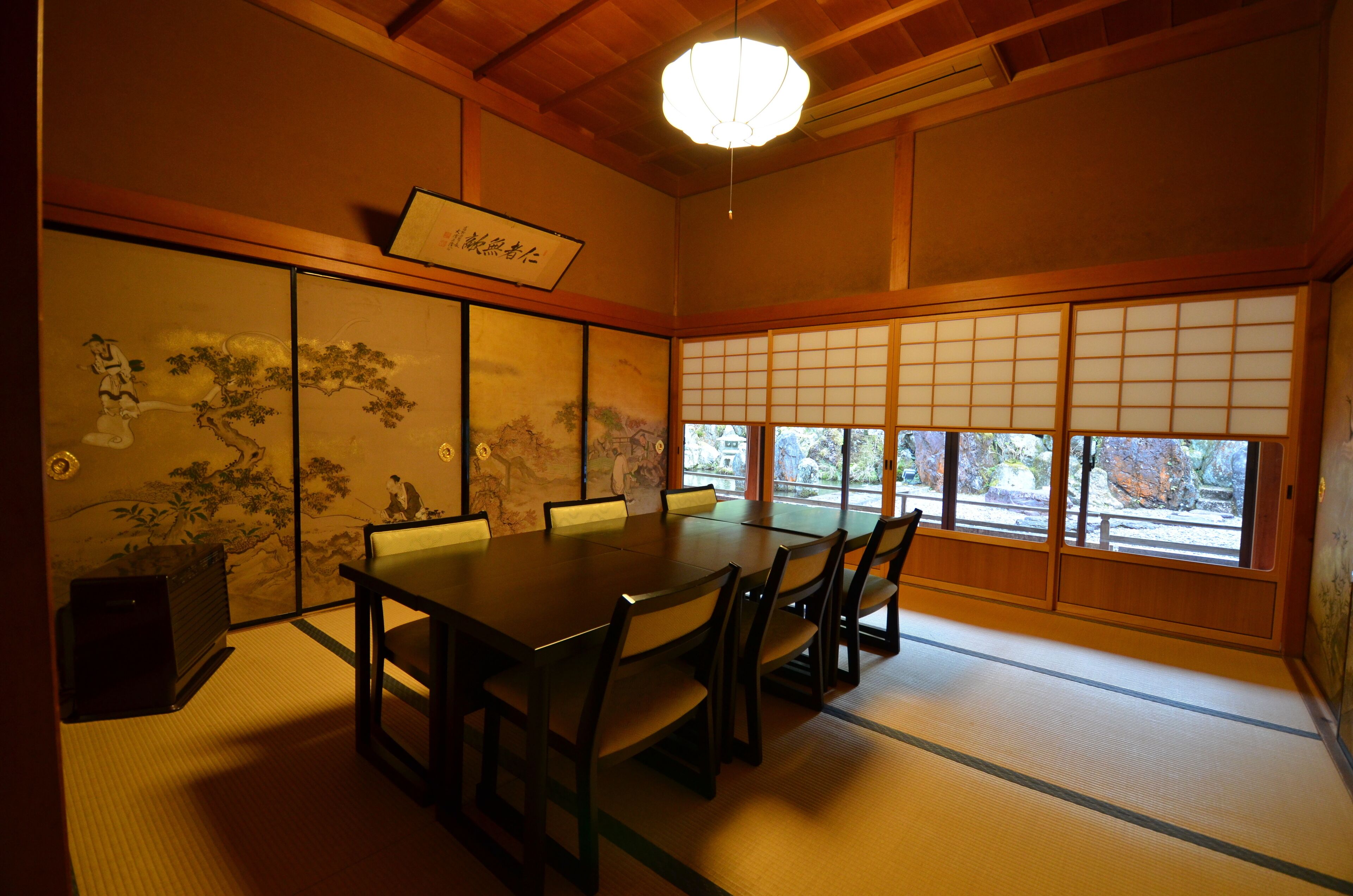 A traditional Japanese room with tatami flooring, a low table, and shoji screens.