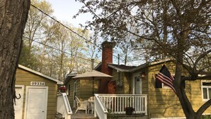 A two-story house with a front porch, a mailbox, and an American flag.