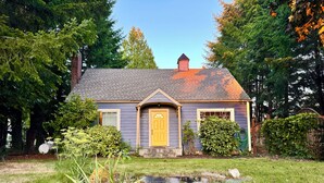 A house with a yellow front door, a chimney, and a small porch.