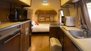 A compact kitchenette with a microwave, a small refrigerator, and a sink. - Grand Camping Palm Garden Maishima (Osaka)