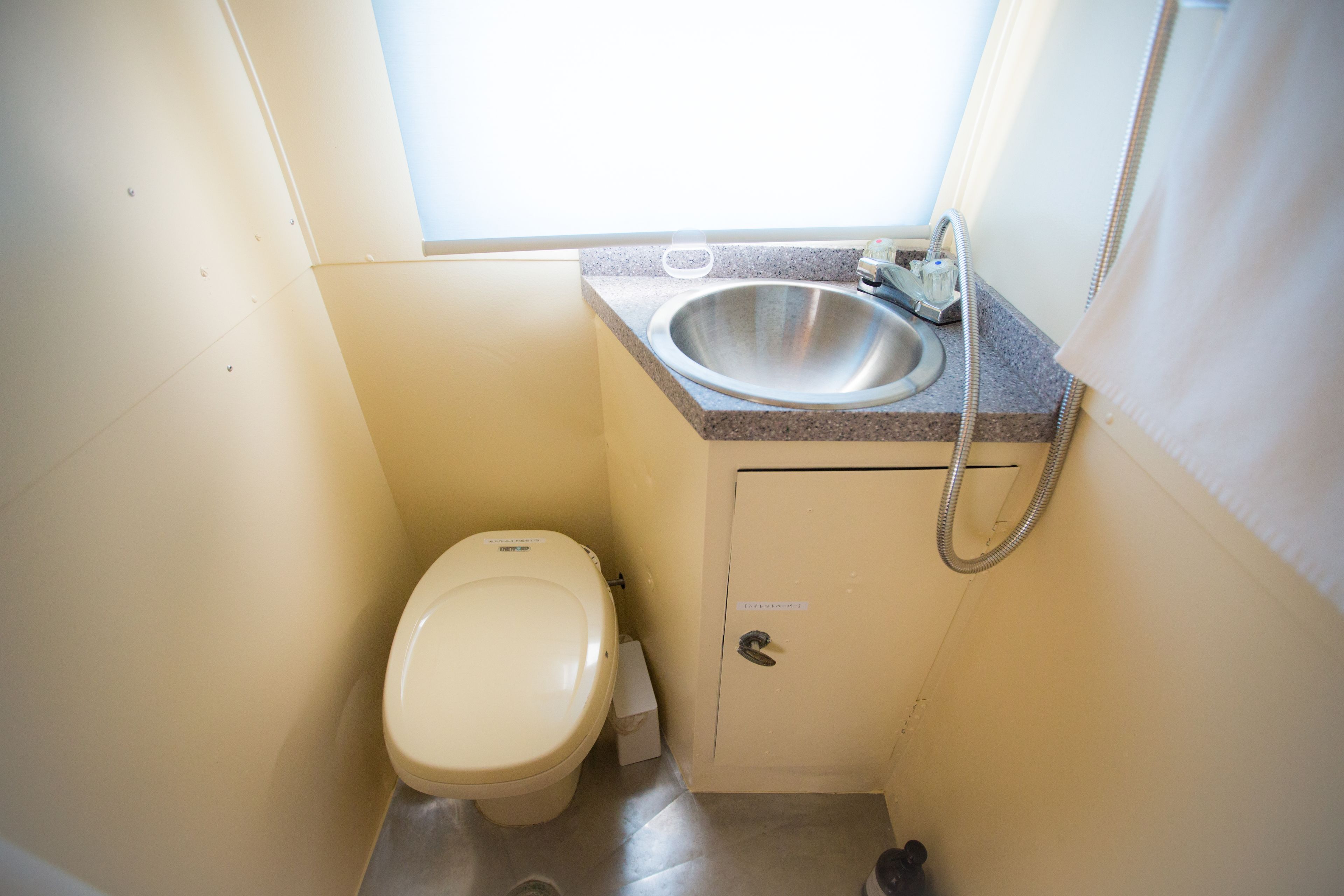 A small bathroom with a toilet, sink, and shower.