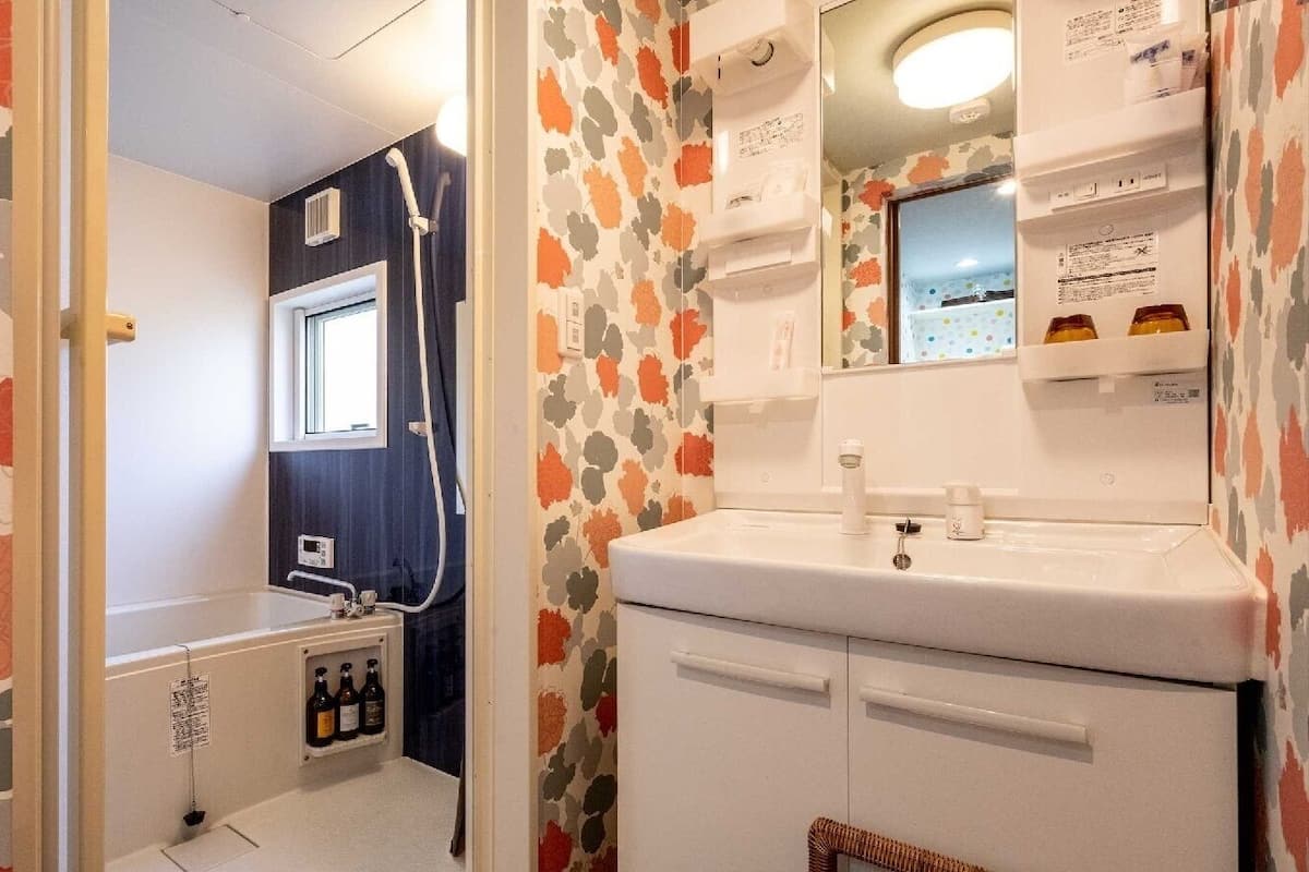 Ein kleines Badezimmer mit Dusche, Waschbecken und Spiegel.