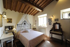 A bedroom with a bed, bedside table, lamp, window, and a dresser. - Typical Tuscan house.Great view on Lucca.Private parking/garden.WIFI             (Lucca)