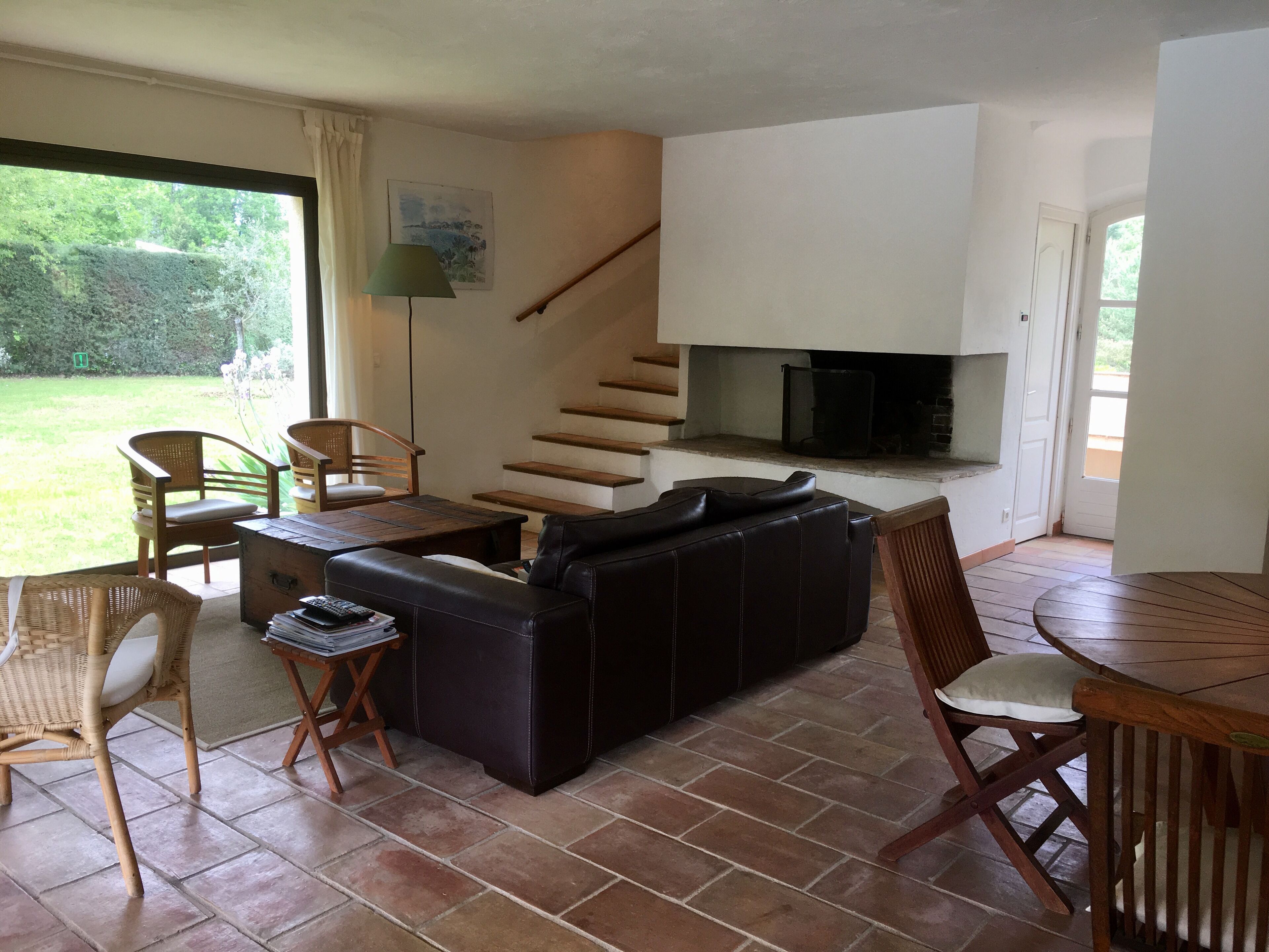 Ein gemütlicher Wohnbereich mit Sofa, Sesseln, einem Tisch und einem Kamin.