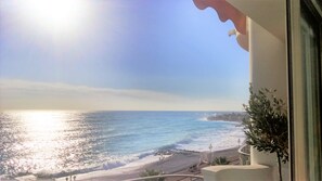 A balcony with a view of the sea and a beach.