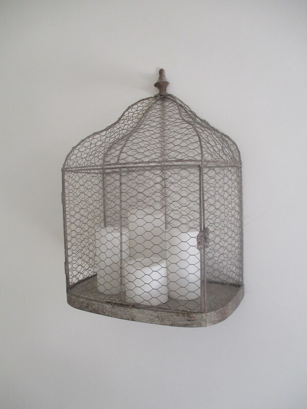 A metal birdcage with a domed top and a small opening at the top, containing three white candles. - In the heart of the historic center and the beach, 2 terraces. For 8 people (Trapani)