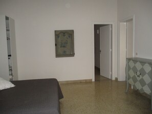 A bedroom with a bed, a dresser, and a door leading to another room. - In the heart of the historic center and the beach, 2 terraces. For 8 people (Trapani)