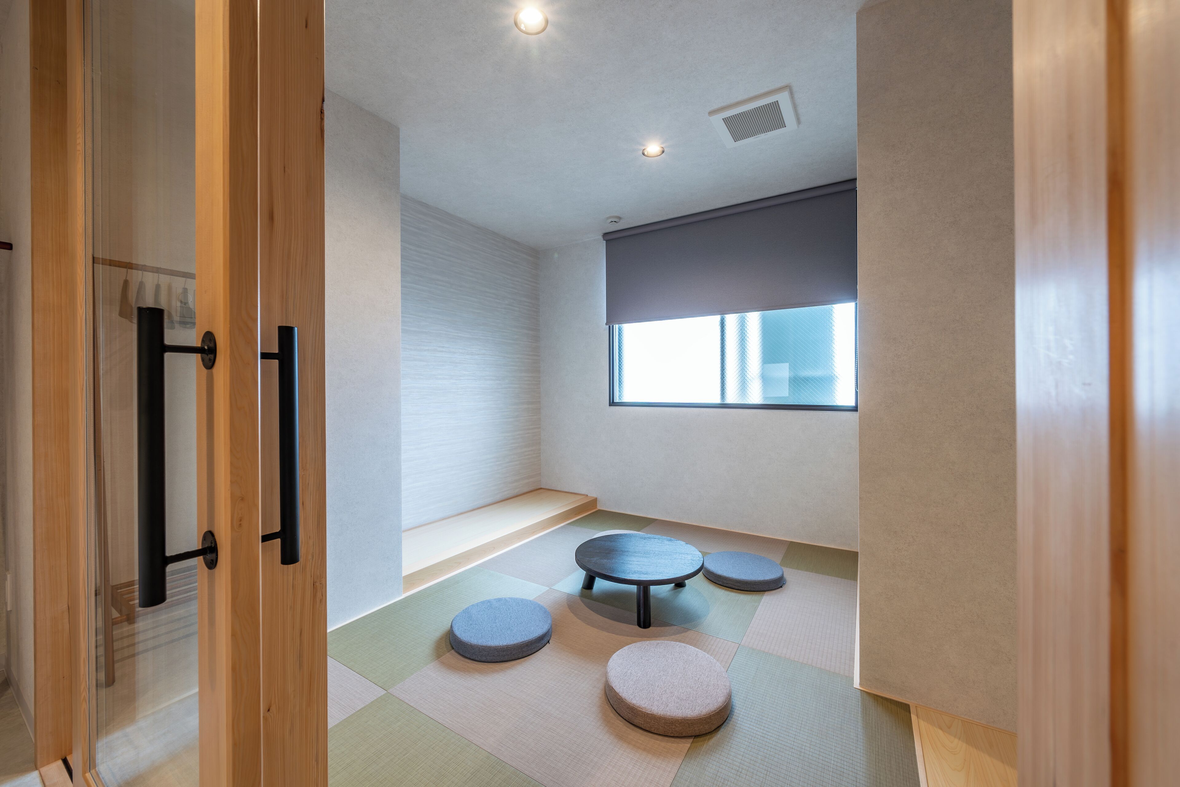Une pièce minimaliste avec des tatamis, une table en tatami et un banc en tatami.