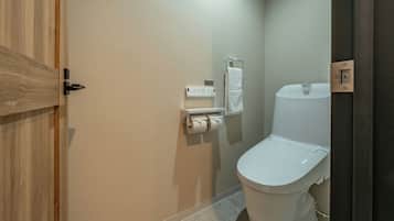 Un baño con inodoro, toallero y dispensador de toallas de papel.