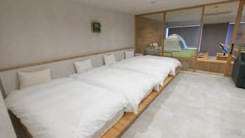 A modern hotel room with a large bed, a wooden headboard, a small bedside table, and a mirror with a sliding door.