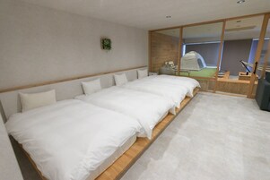 Una habitación de hotel moderna con una cama grande, un cabecero de madera, una mesita de noche pequeña y un espejo con puerta corredera.