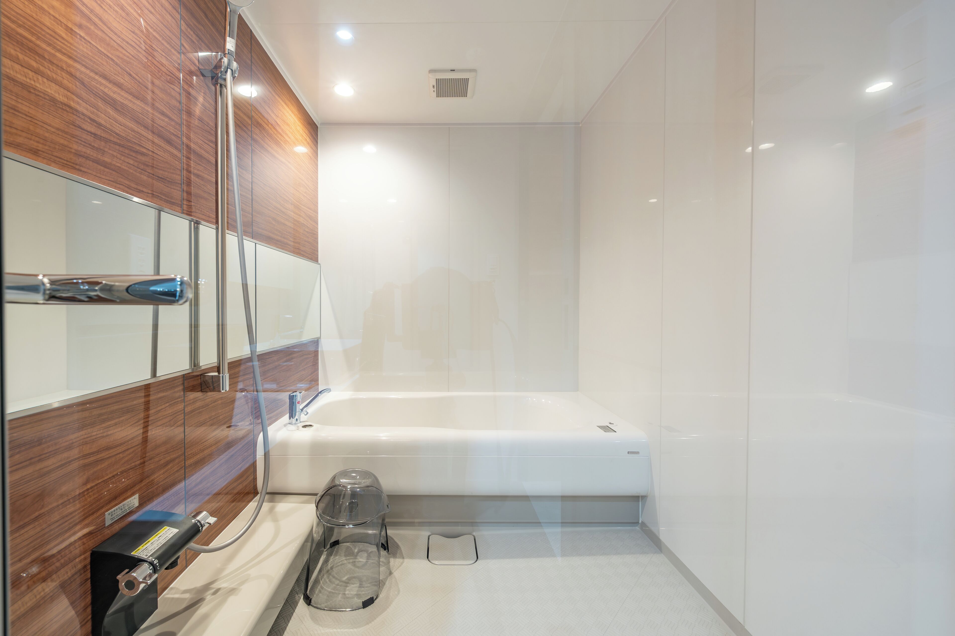 Un baño moderno con cabina de ducha de vidrio, bañera blanca y tocador empotrado con espejo.