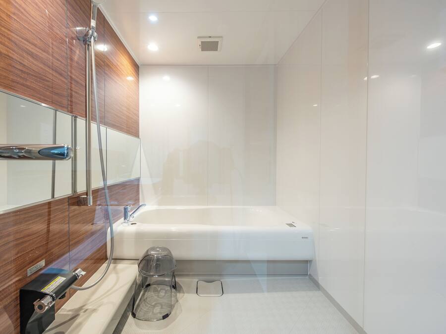 Un baño moderno con cabina de ducha de vidrio, bañera blanca y tocador empotrado con espejo.
