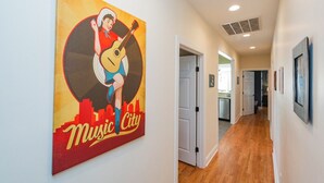 Een gang met een muurschildering van een man die gitaar speelt, en de tekst 'Music City'.