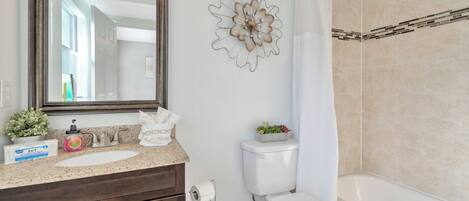 A bathroom with a sink, toilet, and bathtub.