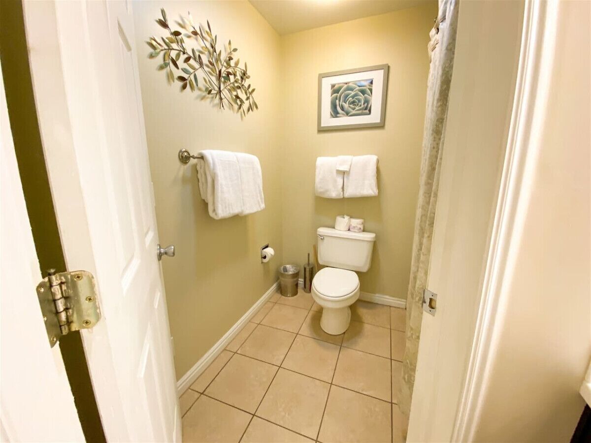 Een badkamer met toilet, wastafel en douchegordijn.