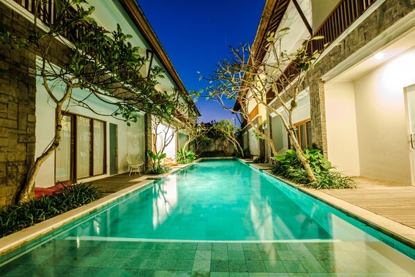 Una piscina al aire libre, tumbonas