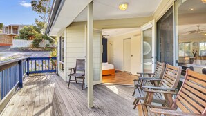 A wooden deck with chairs and a bed in the background. - All Decked Out (Port Willunga)
