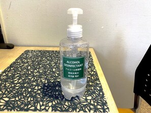 A bottle of alcohol disinfectant on a patterned table. - Tokyo Tower View Guest House (Tokyo)