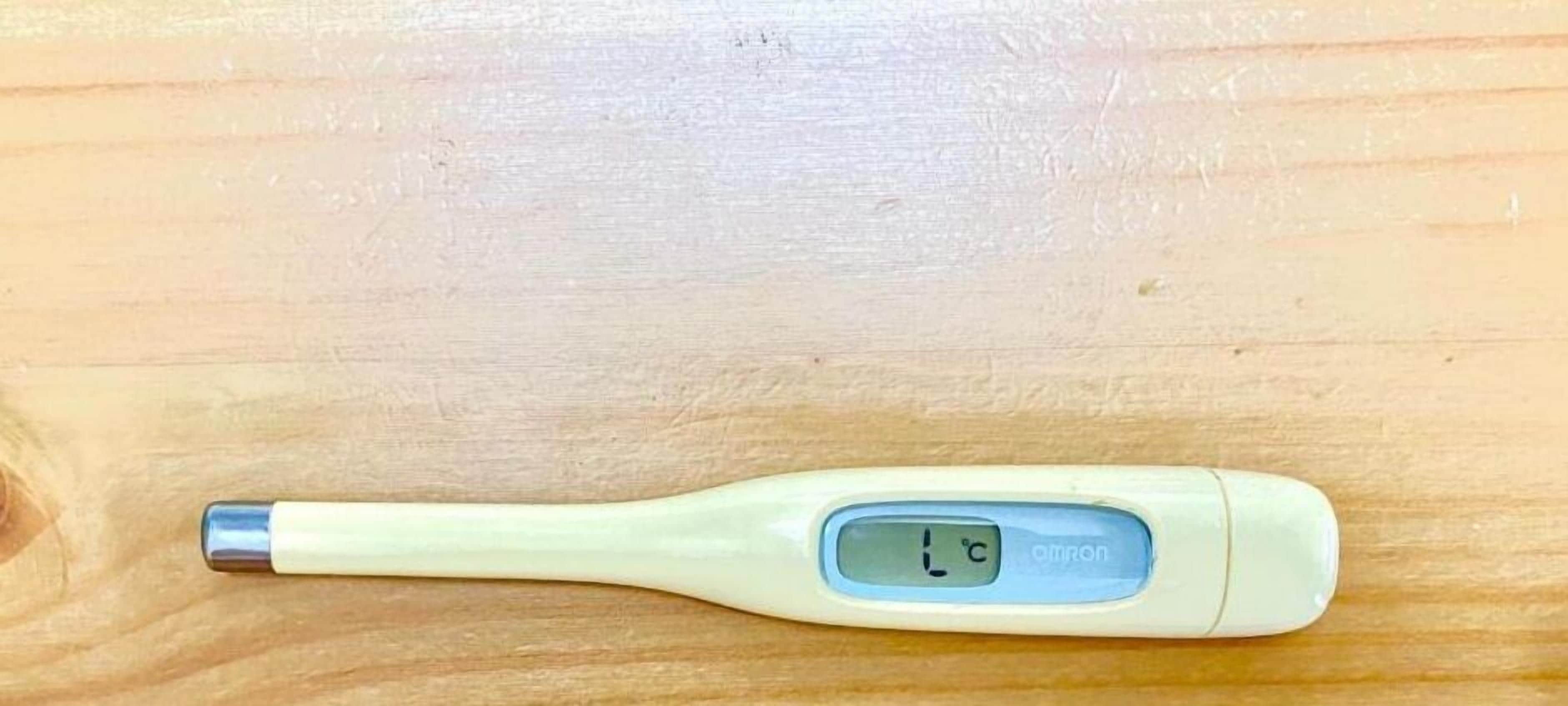 Een digitale thermometer op een houten oppervlak.