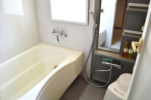 A bathroom with a bathtub, a toilet, a sink, and a mirror. - Tokyo Tower View Guest House (Tokyo)