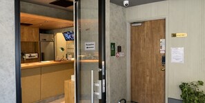 A reception area with a reception desk, a reception sign, a coat check, and a security camera. - Tokyo Tower View Guest House (Tokyo)