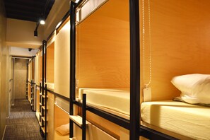 A hotel room with bunk beds, a wooden wall, and a hanging light fixture. - Tokyo Tower View Guest House (Tokyo)
