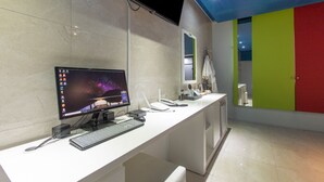 A modern bathroom with a white countertop, a flat-screen TV mounted on the wall, a mirror, and a sink. - Incheon Pentastar Hotel (Incheon)