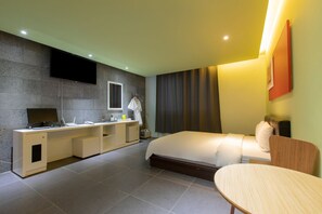 A modern hotel room with a bed, a desk with a flat-screen TV, a small table, and a sofa. - Incheon Pentastar Hotel (Incheon)