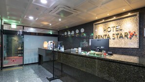 A hotel reception desk with a digital screen, clocks, and a sign reading "HOTEL BENTA STAR". - Incheon Pentastar Hotel (Incheon)