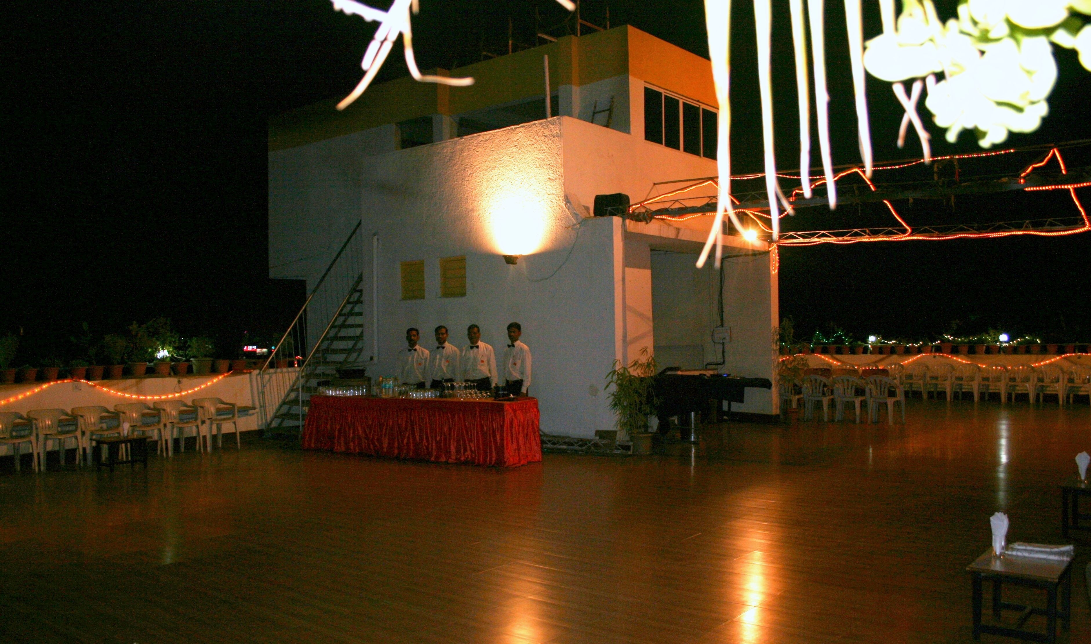 An outdoor event space with a stage, chairs, and a staircase.