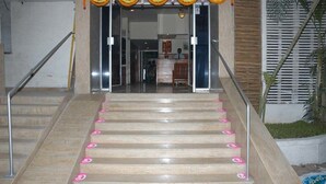 Un escalier menant à un espace d’accueil doté d’un panneau indicateur et d’un comptoir.