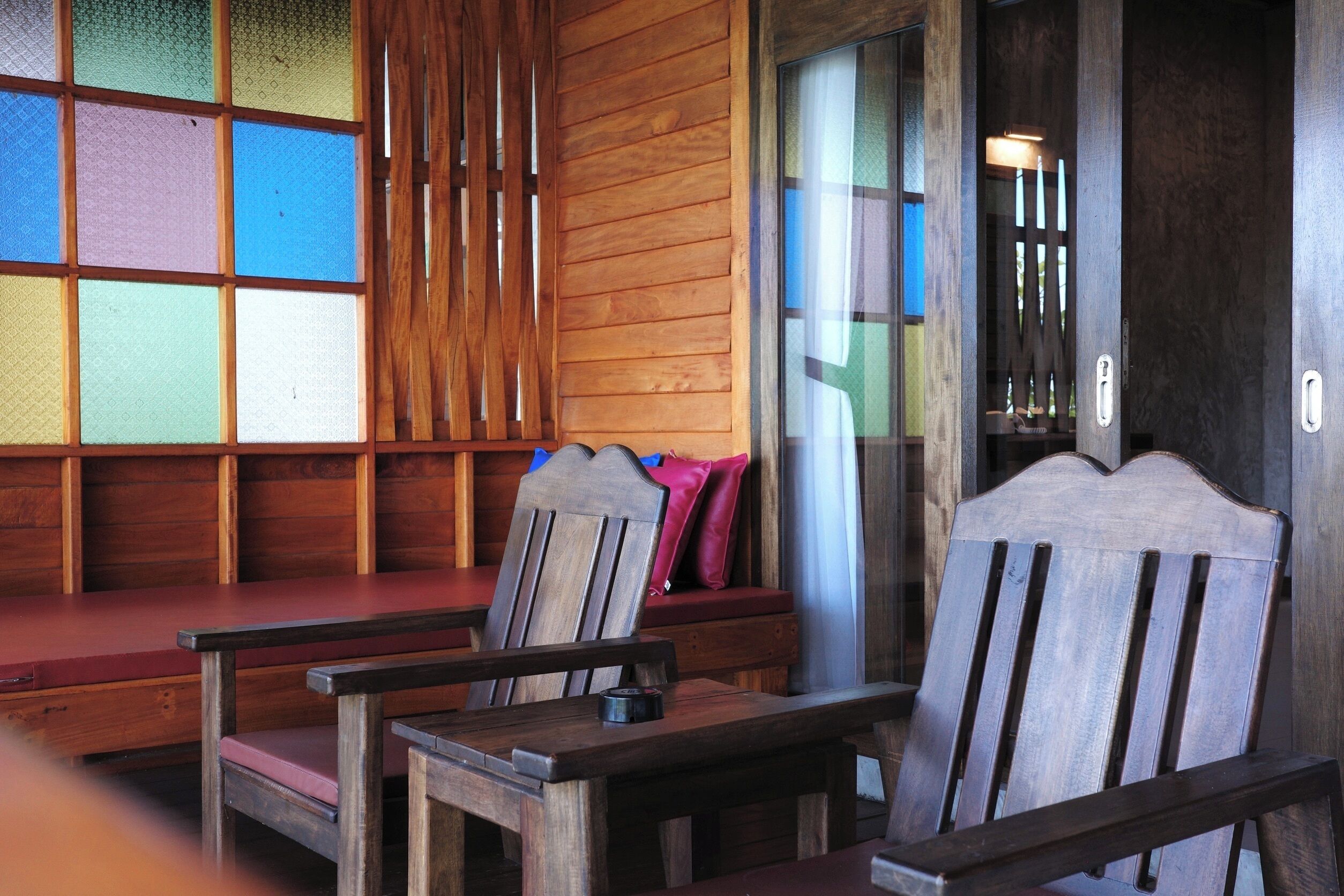 A wooden interior with a bench, a table, and a chair.