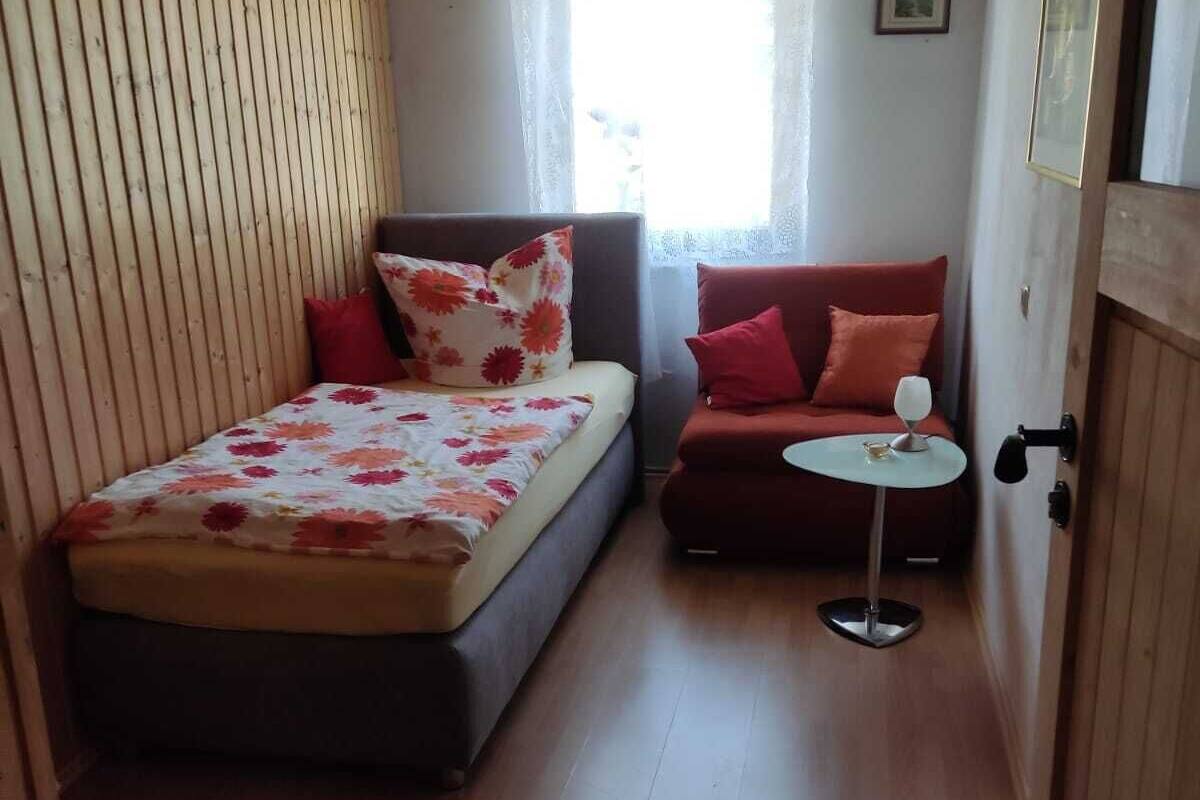 Ein gemütlicher Raum mit einem Bett, einer Couch und einem kleinen Tisch.