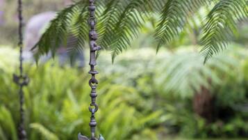 Ein Garten mit einer Metallskulptur, die eine Kette mit Tierfiguren zeigt.