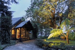 A traditional wooden structure with a sloped roof, surrounded by lush greenery and a well-maintained garden. - Ferncliff (Nuwara Eliya)