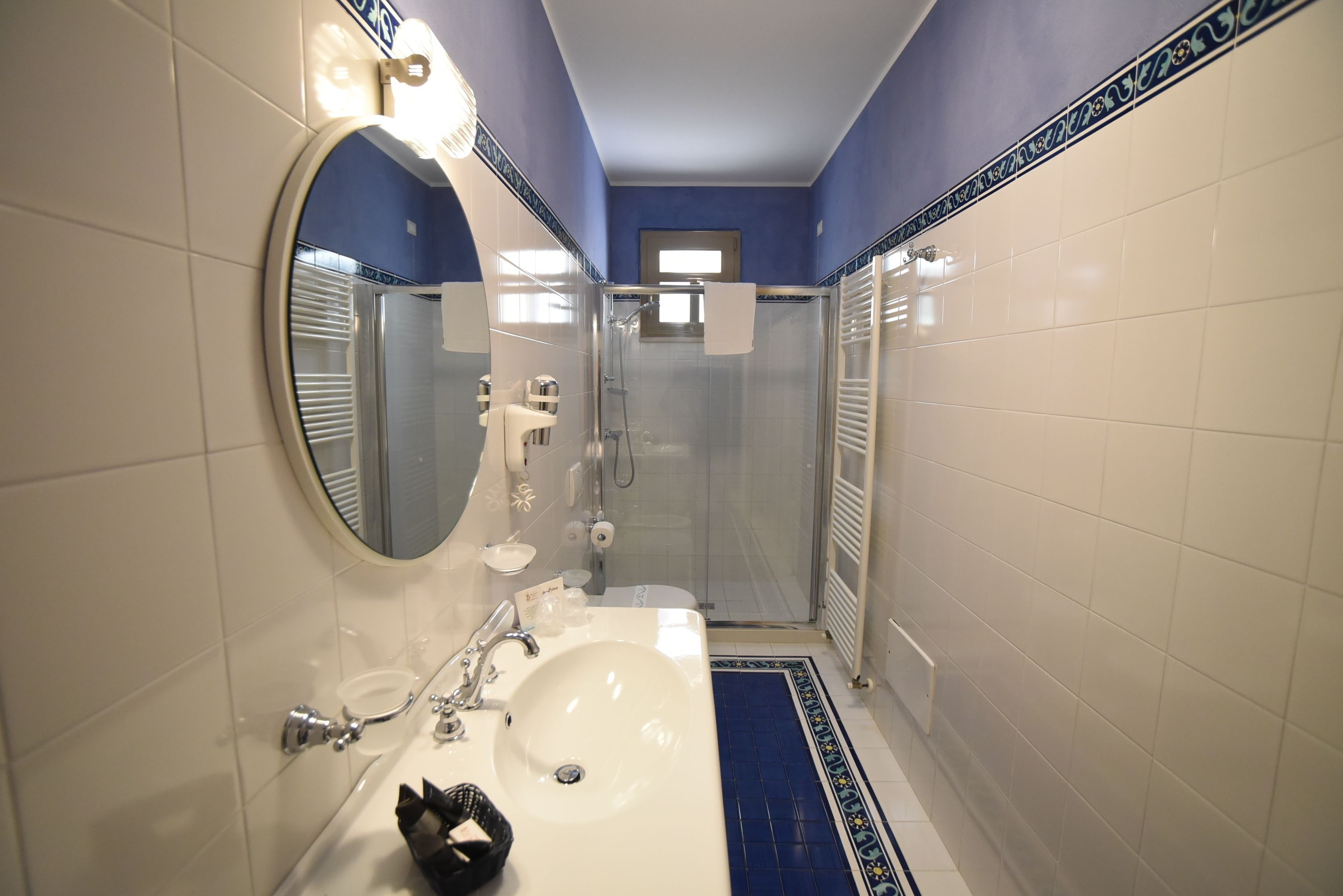 A bathroom with a white sink, mirror, and shower.