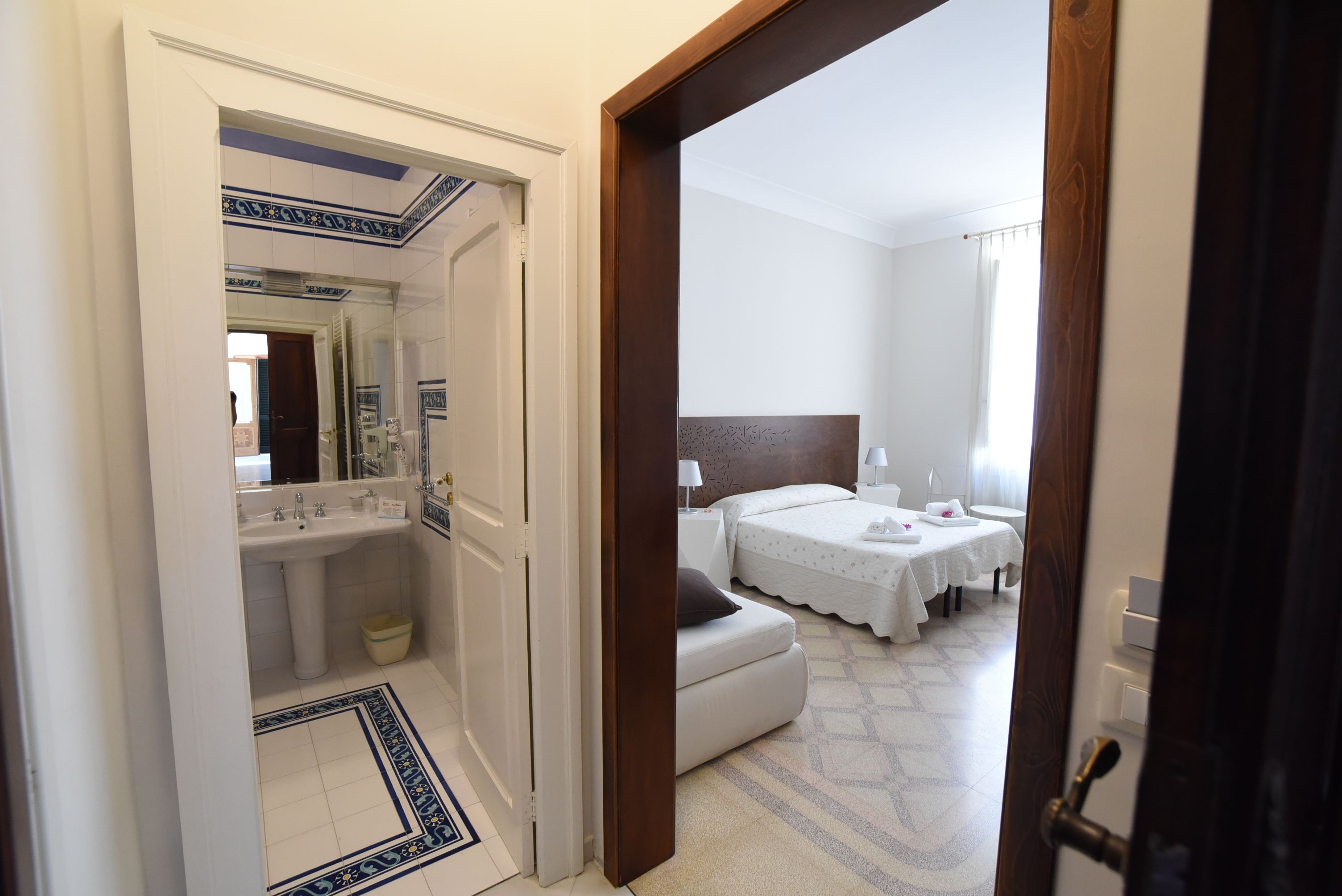 Ein Hotelzimmer mit Bad, Bett, Nachttisch und Beistelltisch.