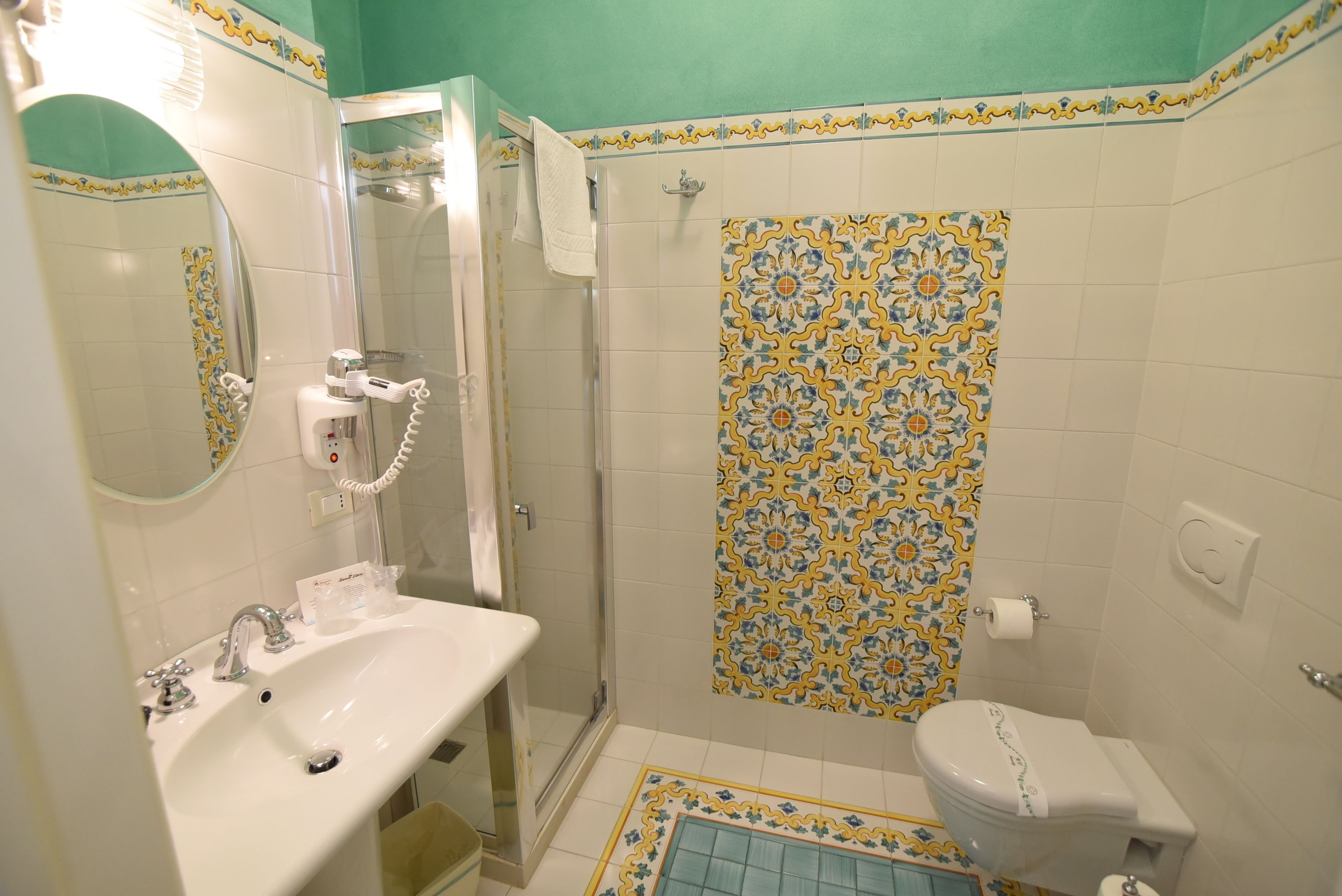 Une salle de bain avec un lavabo, des toilettes et une douche.