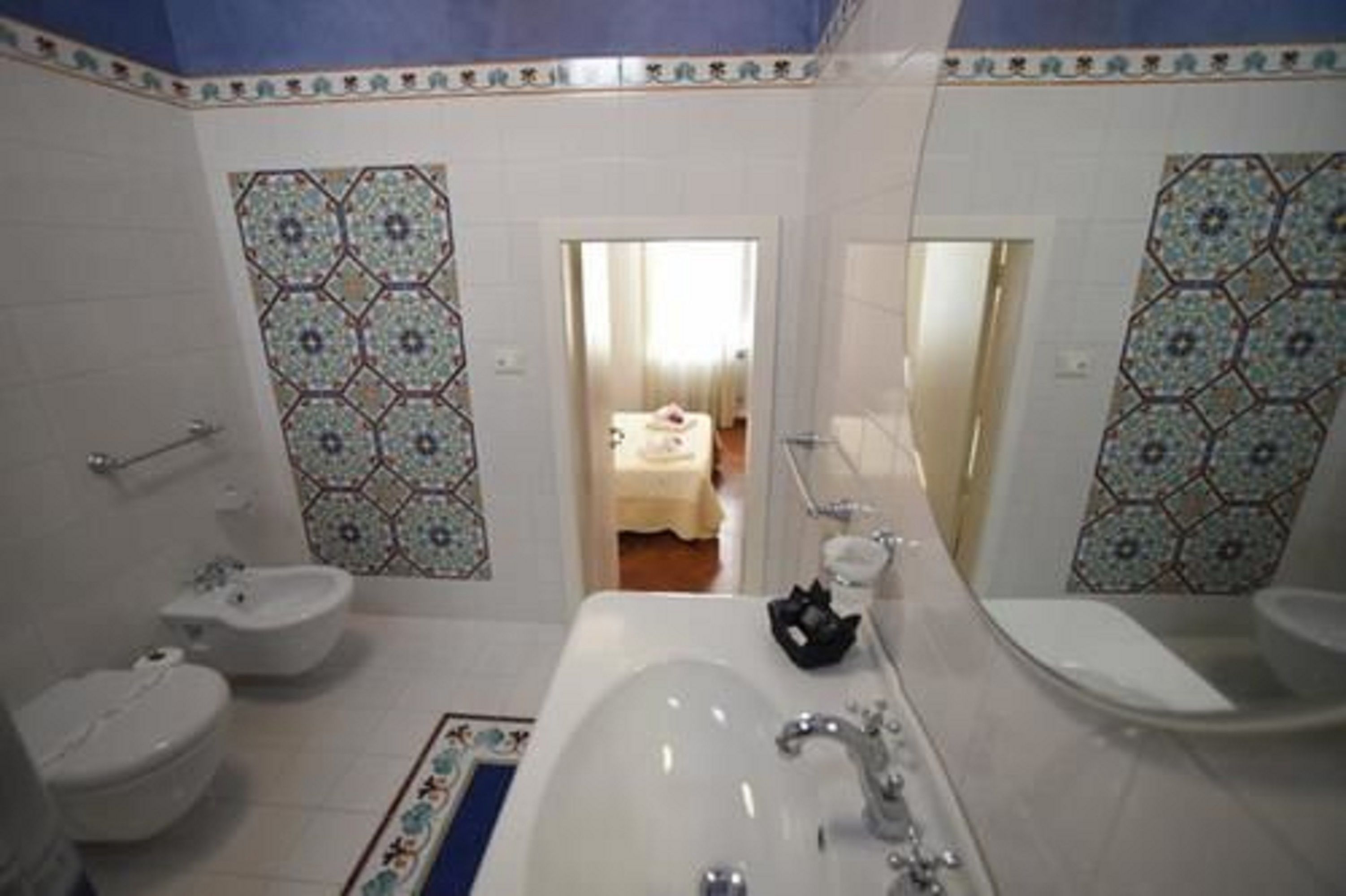 A bathroom with a bathtub, two sinks, and a bidet.