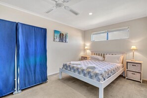 Cozy retreat with a large bed, two bedside tables, and a ceiling fan.