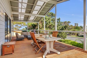 Relax on the deck with a wooden table and comfortable seating for two.