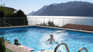 Una piscina con vistas a montañas y un lago.