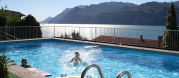 Una piscina al aire libre, sillones reclinables de piscina