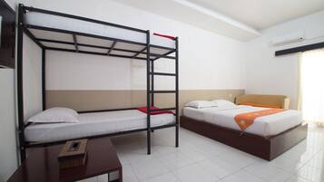 A hotel room with a bunk bed, a single bed, a wooden nightstand, and a window with curtains.