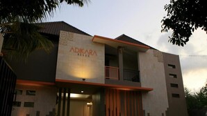 A modern building with the name 'Adikara' on the facade. It features a balcony on the second floor and a large entrance with a door. - Adikara Renon (Denpasar)